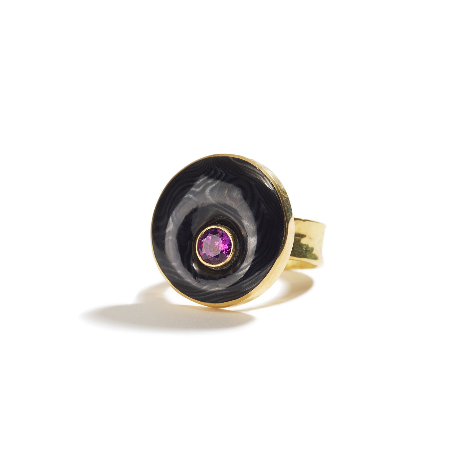 carved psilomelene and a hot pink sapphire set in yellow gold